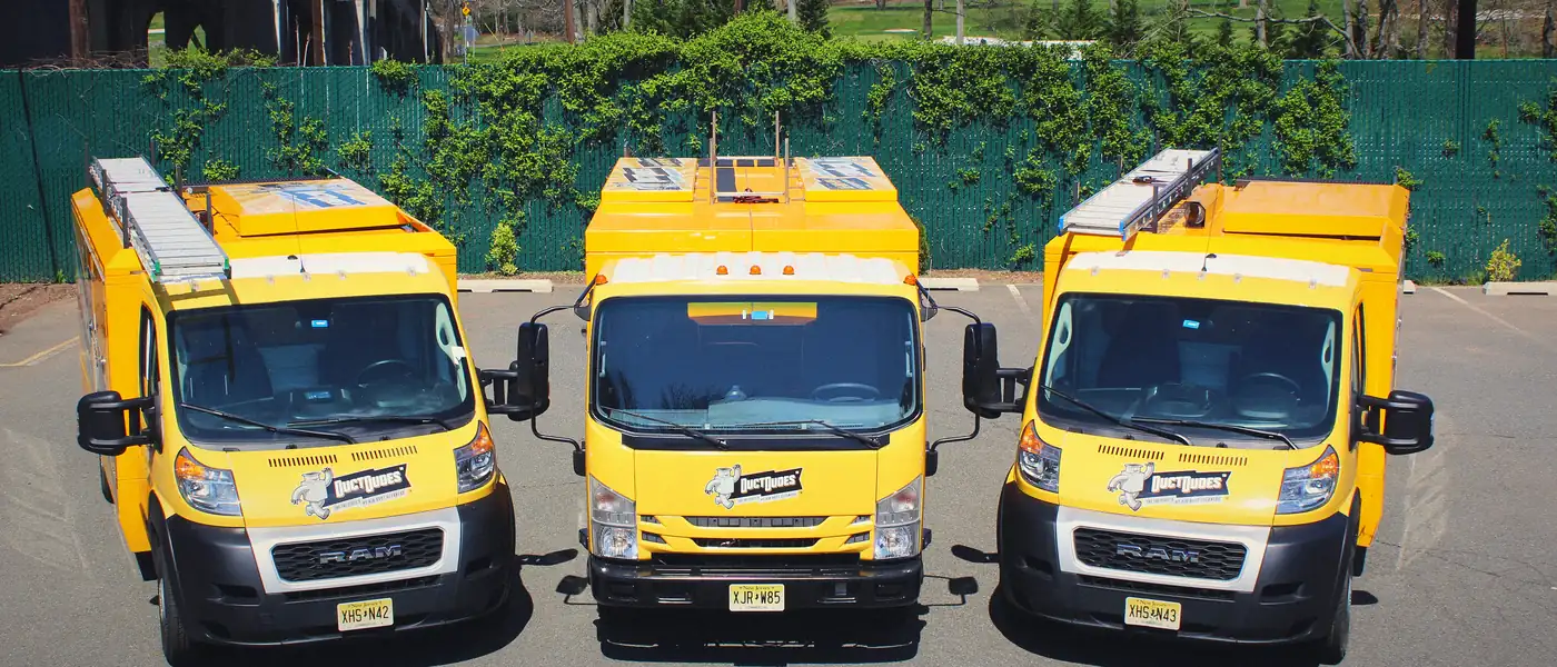 Three Duct Dudes truck-mounted vacuum trucks parked side by side